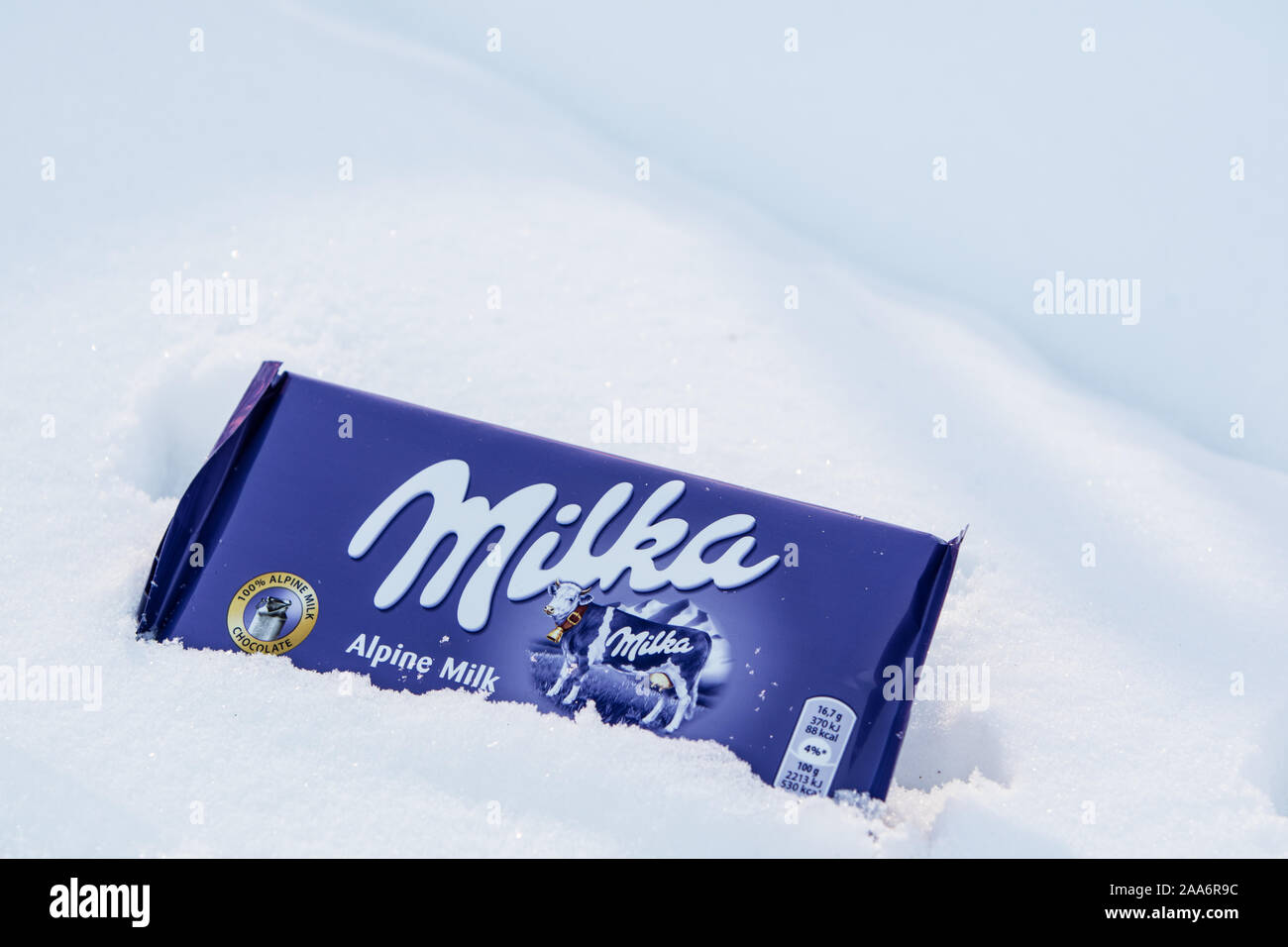 Eine Bar von Milka Mondelez Milch Alpenmilch Schokolade mit der lila Kuh, Winter, Schnee Stockfoto