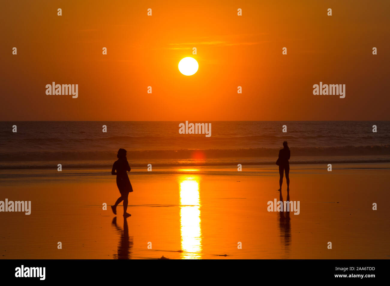Die Leute stehen am Strand, um den Sonnenuntergang zu beobachten. Kuta Beach, Bali. Indonesien Stockfoto