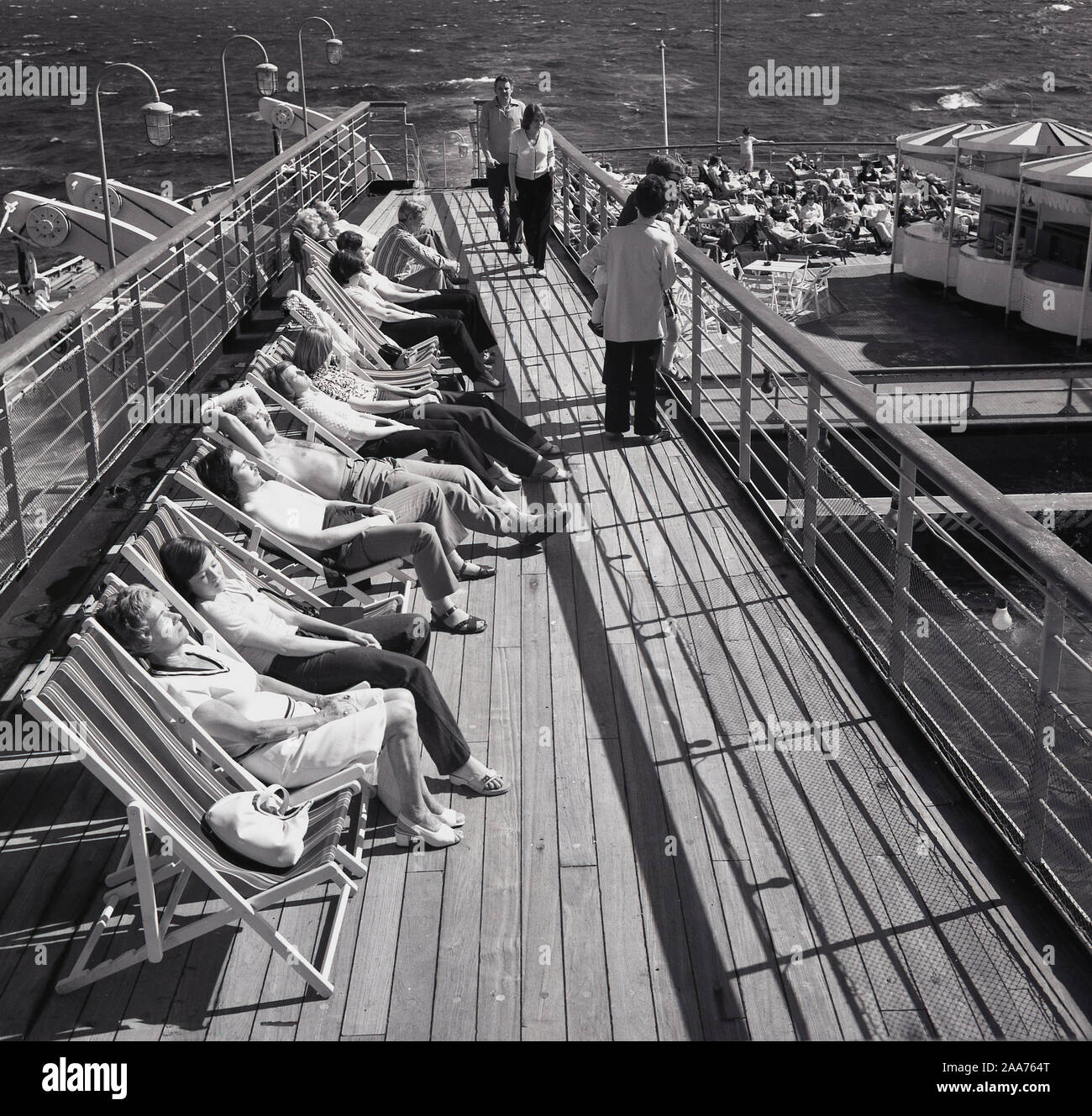 1960, historische, draußen auf dem Meer Passagiere lag in Liegestühlen sonnenbaden an Bord des Kreuzfahrtschiffes Sagafjord. Stockfoto