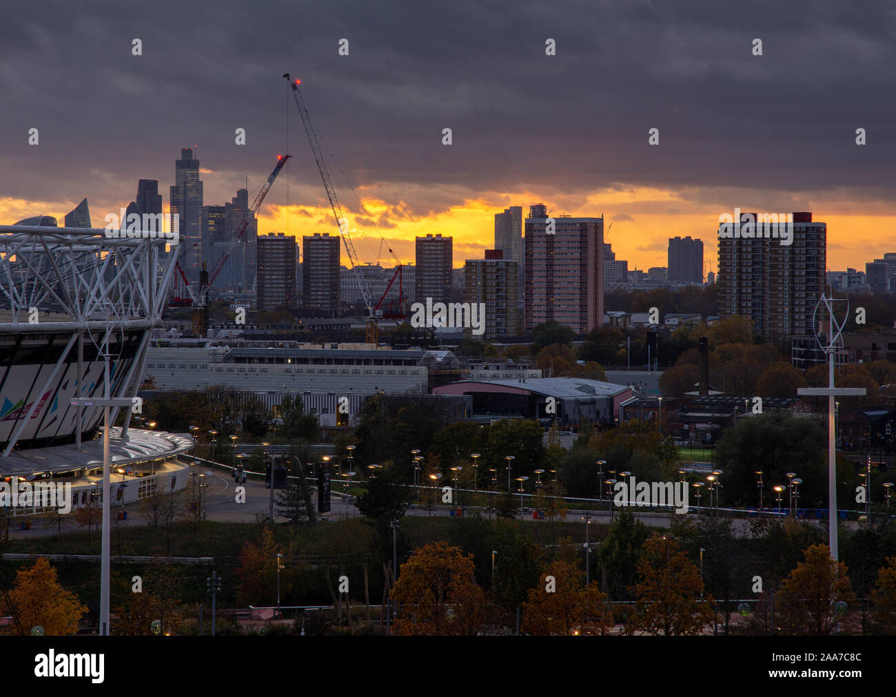 London, England, Großbritannien - 11 November, 2019: Die Sonne hinter der Silhouette der Stadt London und hohes Gehäuse des East End als vom Th gesehen Stockfoto