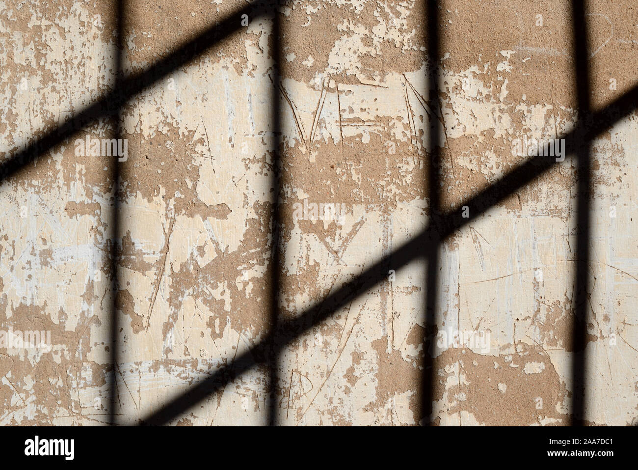 Schattenmuster auf alte Mauer aus Metallstangen oder Iron-Barred Windows im ehemaligen Gefängnis oder Gefängniszelle Stockfoto