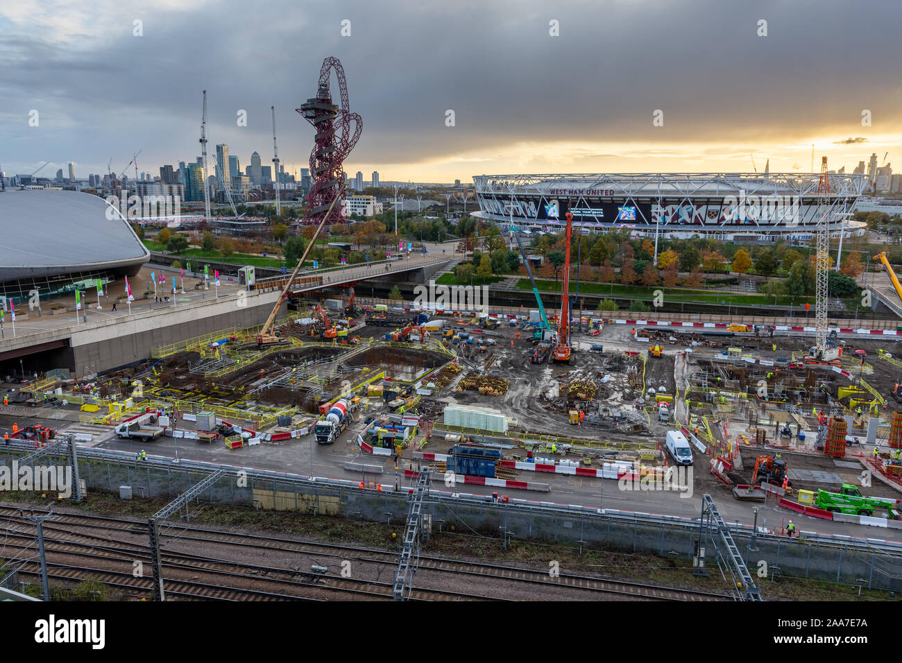 London, England, Großbritannien - 4. November 2019: Bauherren pwork auf einer Baustelle im Olympischen Park mit dem Londoner Stadion und Skyline hinter sich. Stockfoto