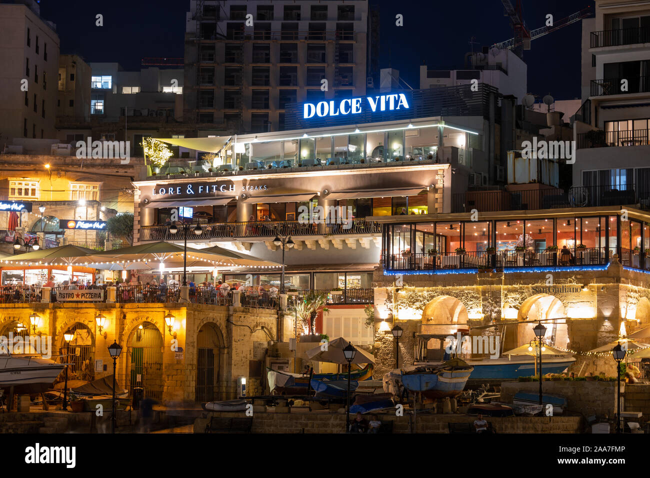 Paceville, St Julians, Malta - 10. Oktober 2019: Restaurants Dolce Vita, Lore und Fitch und San Giuliano in Paceville, Saint Julian Stadt bei Nacht Stockfoto