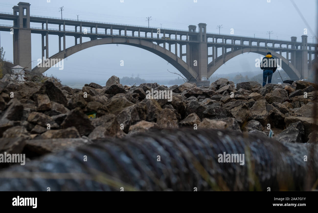 Die Verschmutzung der Flüsse der Industrie. schmutzige Industrial Pipe umweltschädliche River. Fischer Fische in einem dreckigen Fluss. Brücke über den Fluss Stockfoto