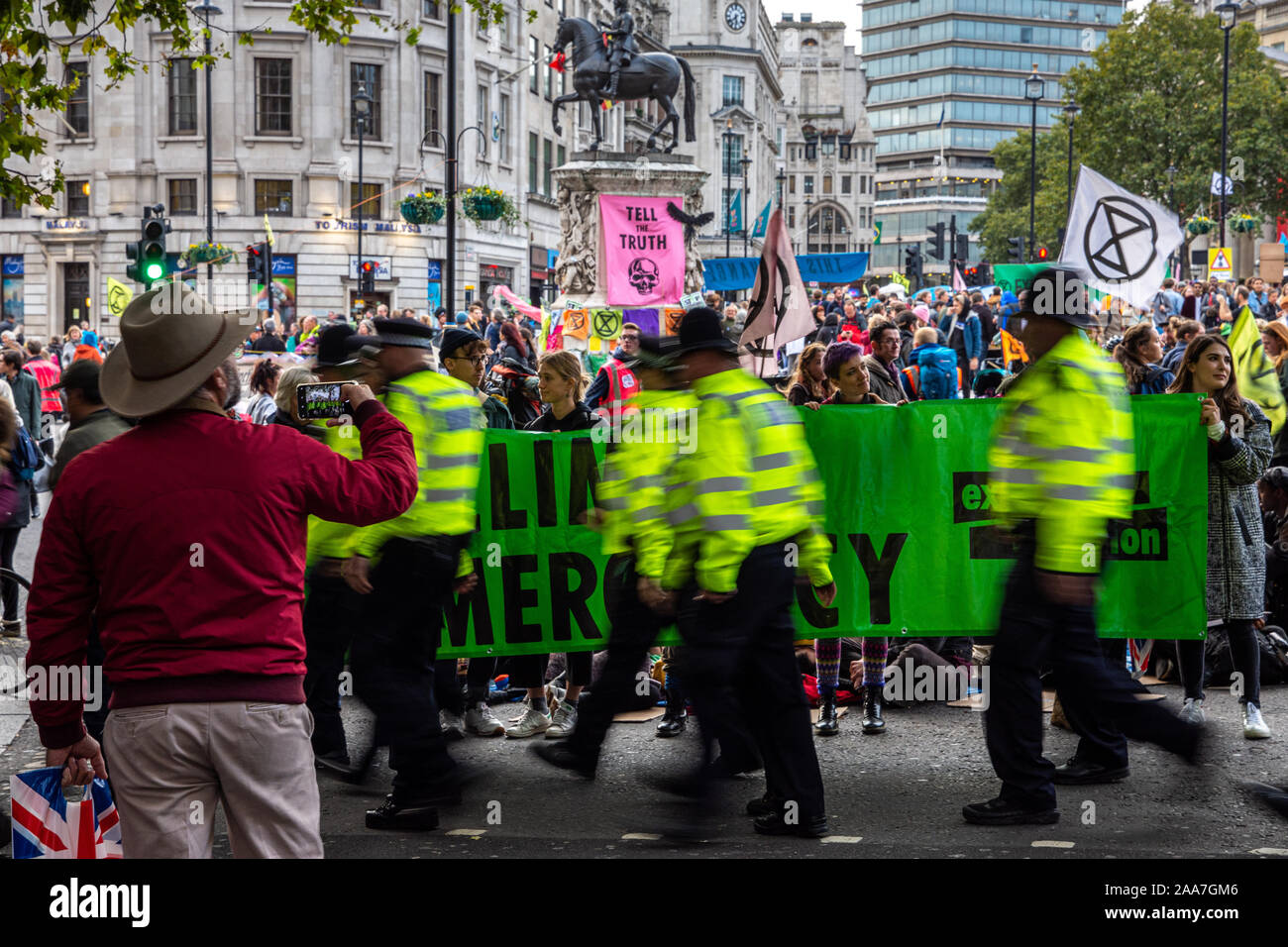 London, England, UK - Oktober 10, 2019: ein Tourist nimmt ein Foto einer Aussterben Rebellion Protest auf dem Trafalgar Square in London. Stockfoto