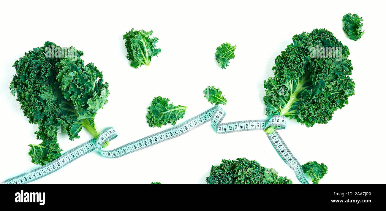 Kale eingewickelt in Maßband, Konzept Diät, Abnehmen, gesunde Ernährung, oben Stockfoto
