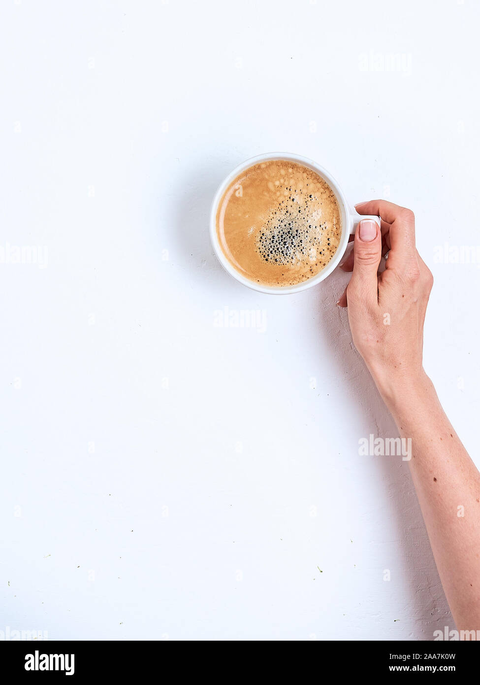 Kaffeetasse in weibliche Hände auf einem weißen Hintergrund. Ansicht von oben Stockfoto
