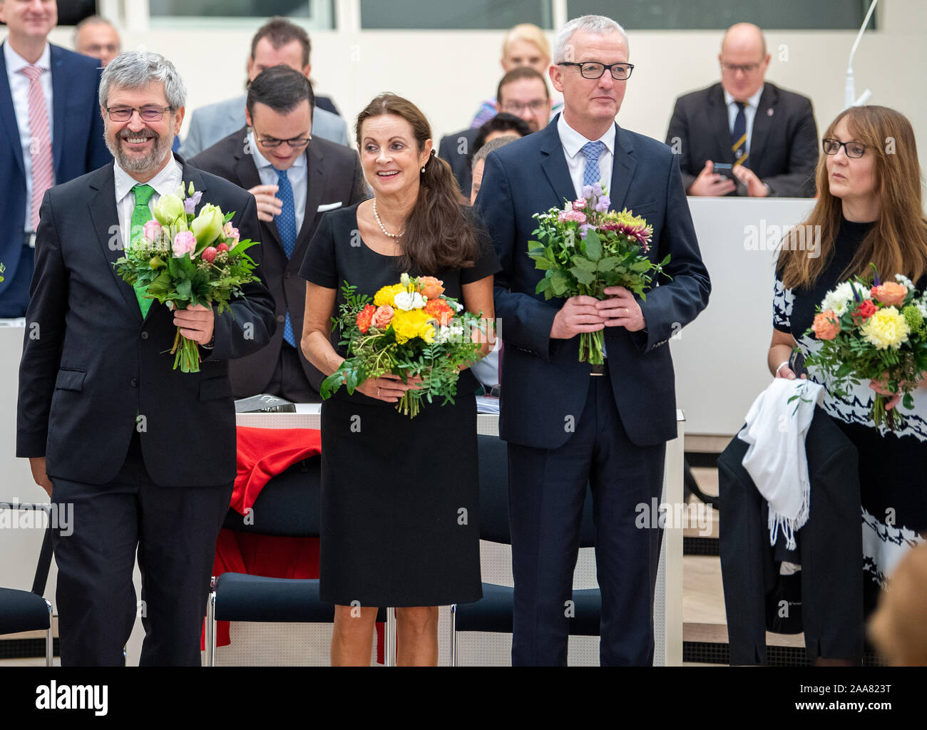 20 November 2019, Brandenburg, Potsdam: Die neuen Mitglieder der Brandenburger Landesregierung (vordere Reihe, l-r): Axel Vogel (Bündnis 90/Die Grünen), Minister für Landwirtschaft, Umwelt und Klima von Brandenburg, Susanne Hoffmann (CDU), Minister für Justiz des Landes Brandenburg, Guido Beermann (CDU), Minister für Infrastruktur und Planung von Brandenburg, und Katrin Lange (SPD), Minister für Finanzen und Europa von Brandenburg, stehen im Plenarsaal des Brandenburger Landtags nach ihrer Vereidigung mit Blumen. Foto: Monika Skolimowska/dpa-Zentralbild/dpa Stockfoto