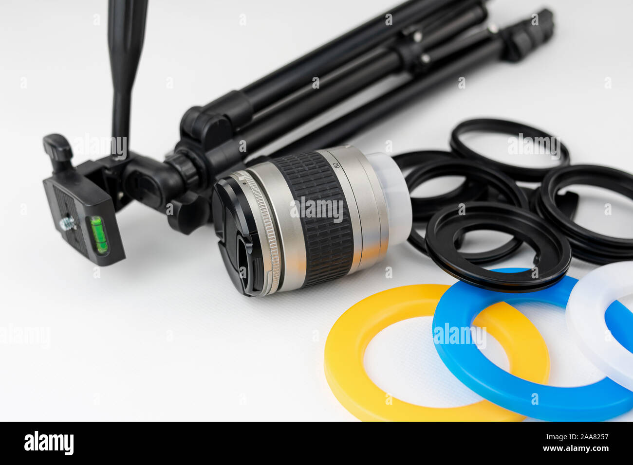 Kleines Stativ, Kamera Objektiv, Farbfilter und Adapter Ringe auf weißem Hintergrund Stockfoto