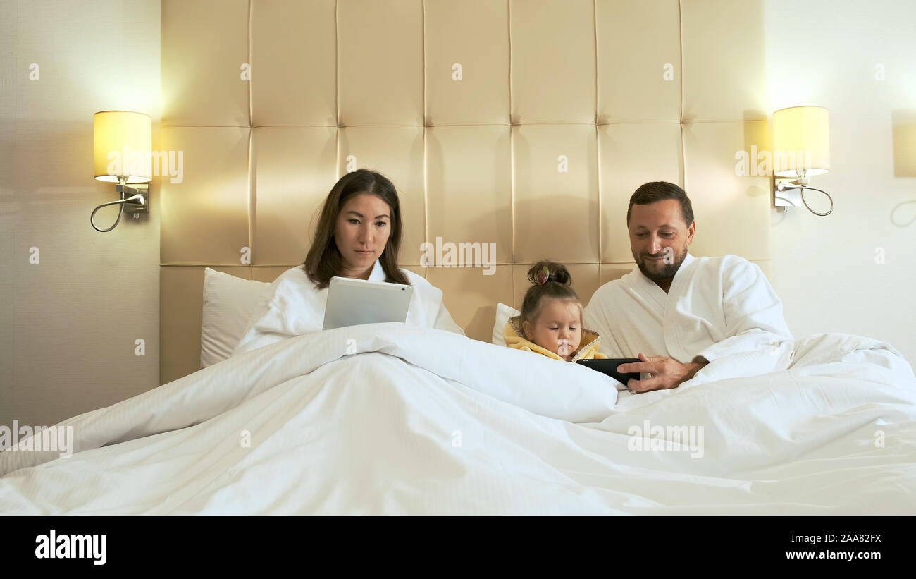 Mutter, Vater und Tochter in Bademänteln vorbereiten, abends zu schlafen Stockfoto