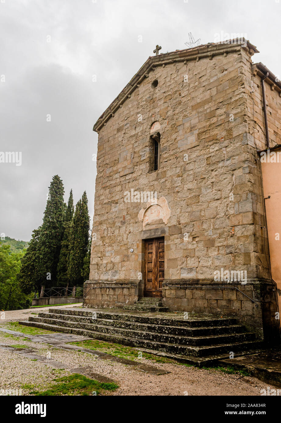 Mittelalterliche Pfarrkirche Fassade mit Zypressen in Italien Stockfoto