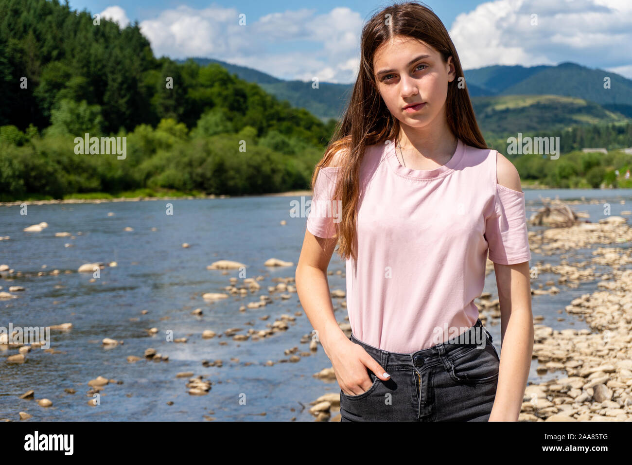 Jugendlich Mädchen schauen in die Kamera mit Berg und Fluss hinter Stockfoto