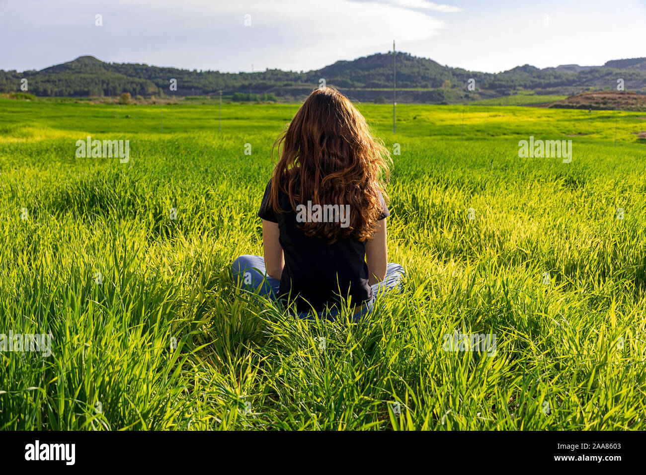 Junge kaukasier Frau rot - mit Sommersprossen blonde, ruht auf der grünen Wiese am Frühling Sonnenuntergang, sitzen in einem Yoga Position. Meditation, Achtsamkeit, entspannen Stockfoto