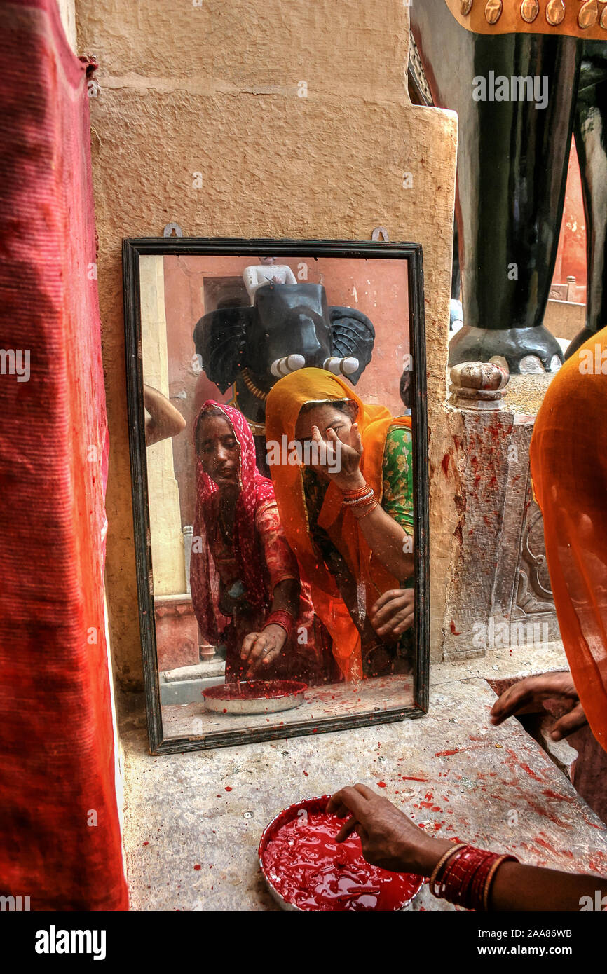 Bikaner, Rajasthan, Indien: Zwei indische Frauen in Junagarh Fort gelten Bindi Blick in den Spiegel (rote Markierung in der Mitte der Stirn). Stockfoto
