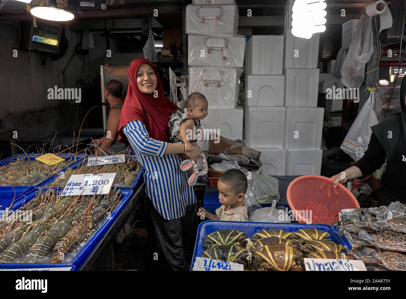 Muslimische Mutter mit Kind arbeiten an ihrem Lebensmittelmarkt satll. Fischmarkt in Pattaya, Thailand, Südostasien Stockfoto