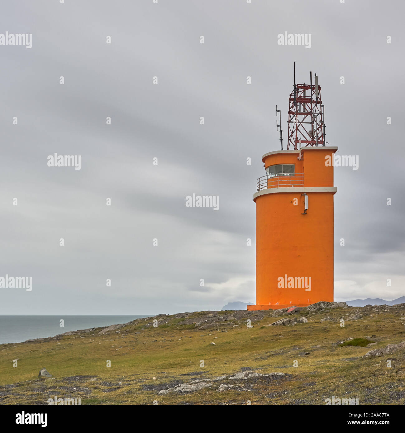 Dieses schöne orange Leuchtturm steht an der Küste im Südosten Islands. Stockfoto