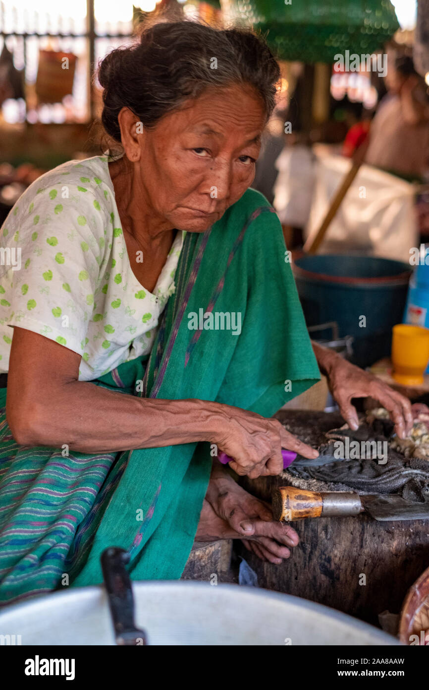 Die lebendige Fleisch, Fisch, Gemüse und Obst von Pakokku, Myanmar (Birma) mit einer älteren Frau, die Vorbereitung/verkaufen frische Meeresfrüchte mit einem Stirnrunzeln auf ihrem Gesicht Stockfoto