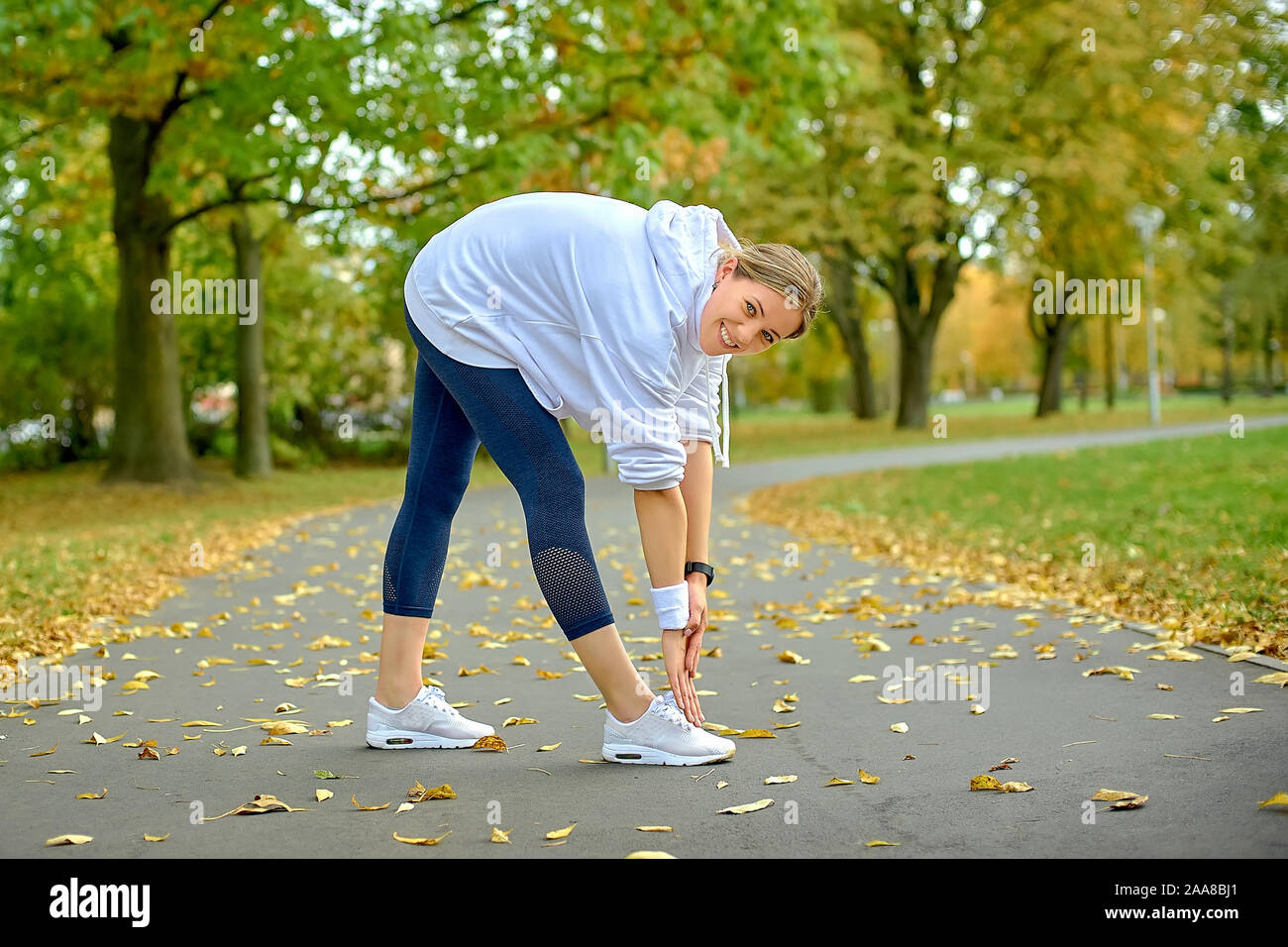 Mädchen Athlet in einer einheitlichen Aufwärmen vor dem Joggen auf einem Track im Park ist, gesunden Lebensstil Stockfoto