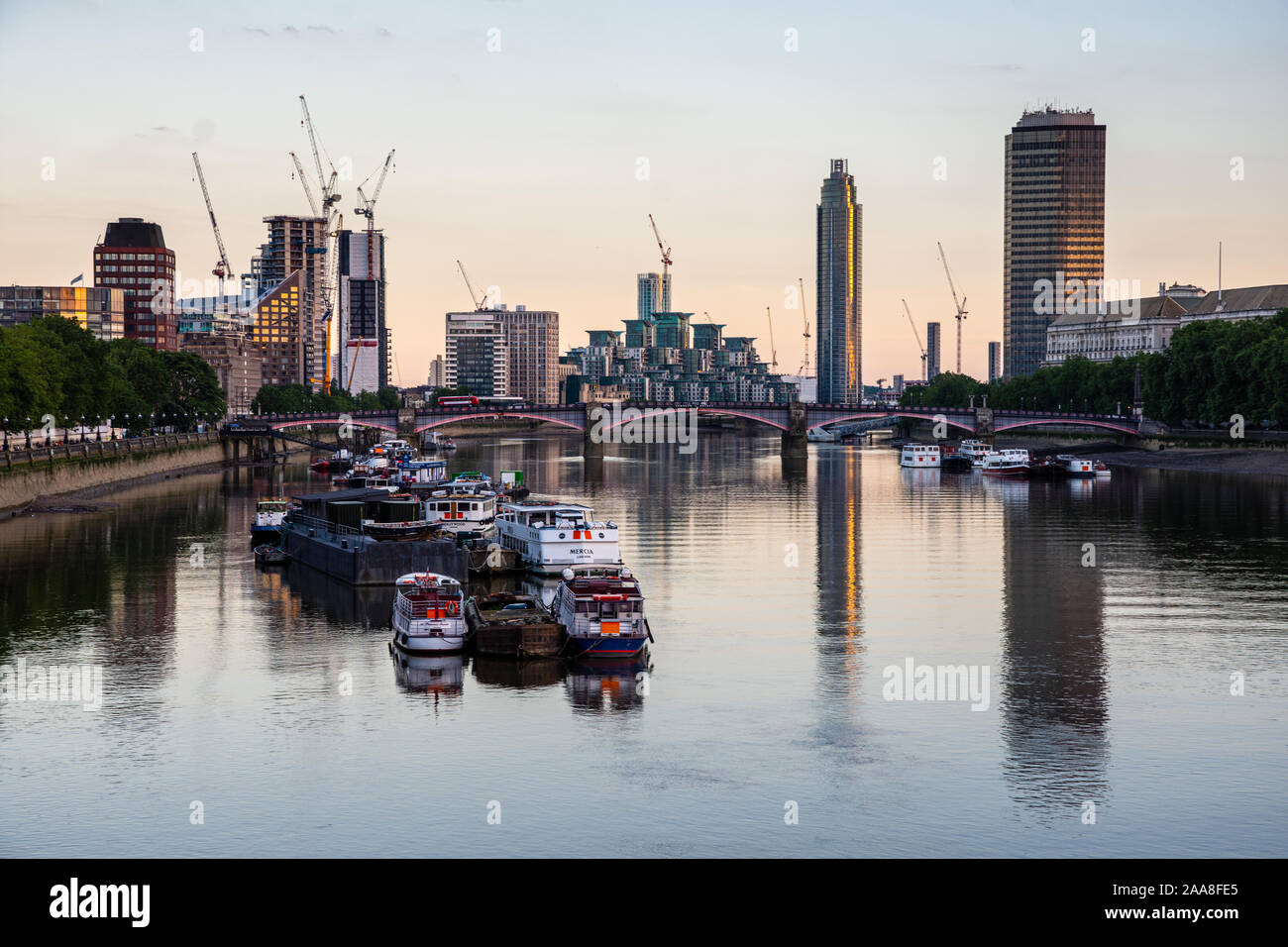 London, England, Großbritannien - 3. Juli 2016: Dämmerung über Lambeth Bridge und Fähren in der Themse vor Anker, mit der Skyline von Vauxhall und neun Elms Stockfoto