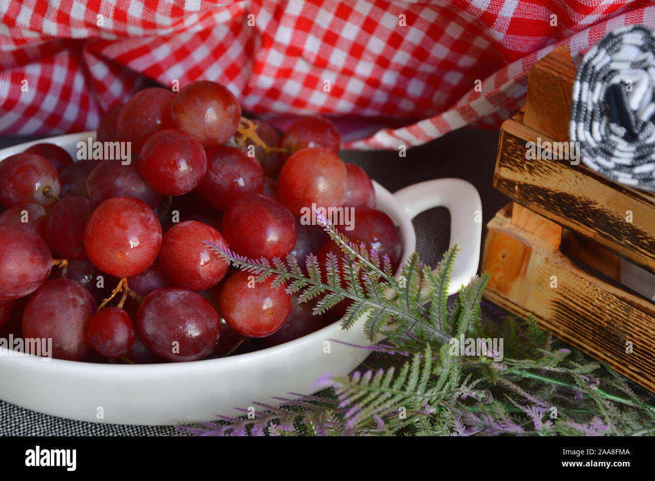 Rote Trauben mit Wassertropfen in weiße Platte Stockfoto