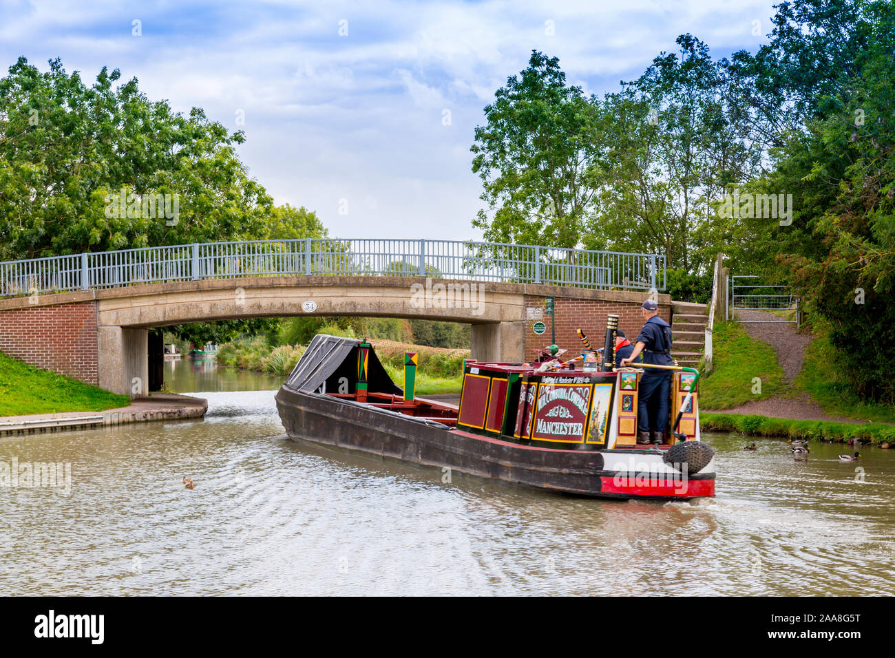 Eine bunte Longboat auf der Ashby-de-la-Zouch Canal verläuft unter Sutton Wharf Brücke, Leicestershire, England, Großbritannien Stockfoto