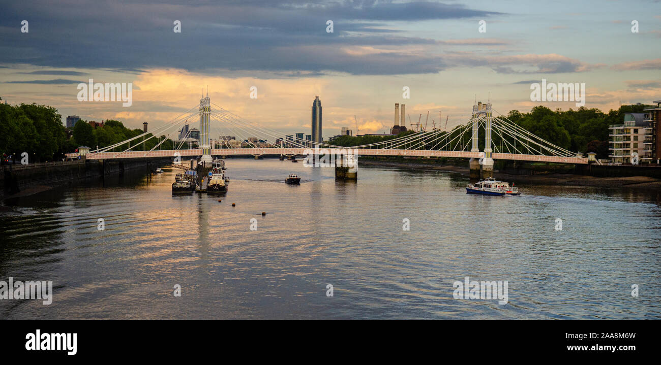 London, England, UK - 13. Mai 2014: Sonnenuntergang auf der Themse in Battersea in London, mit der Albert Bridge und die Skyline einschließlich St George. Stockfoto