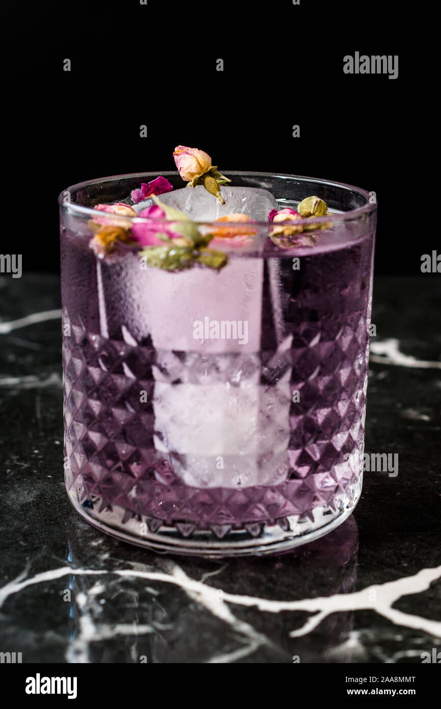 Pink Gin Tonic Cocktail mit Getrocknete Rosenknospen und Eis im Glas Schale. Bereit zu trinken. Stockfoto