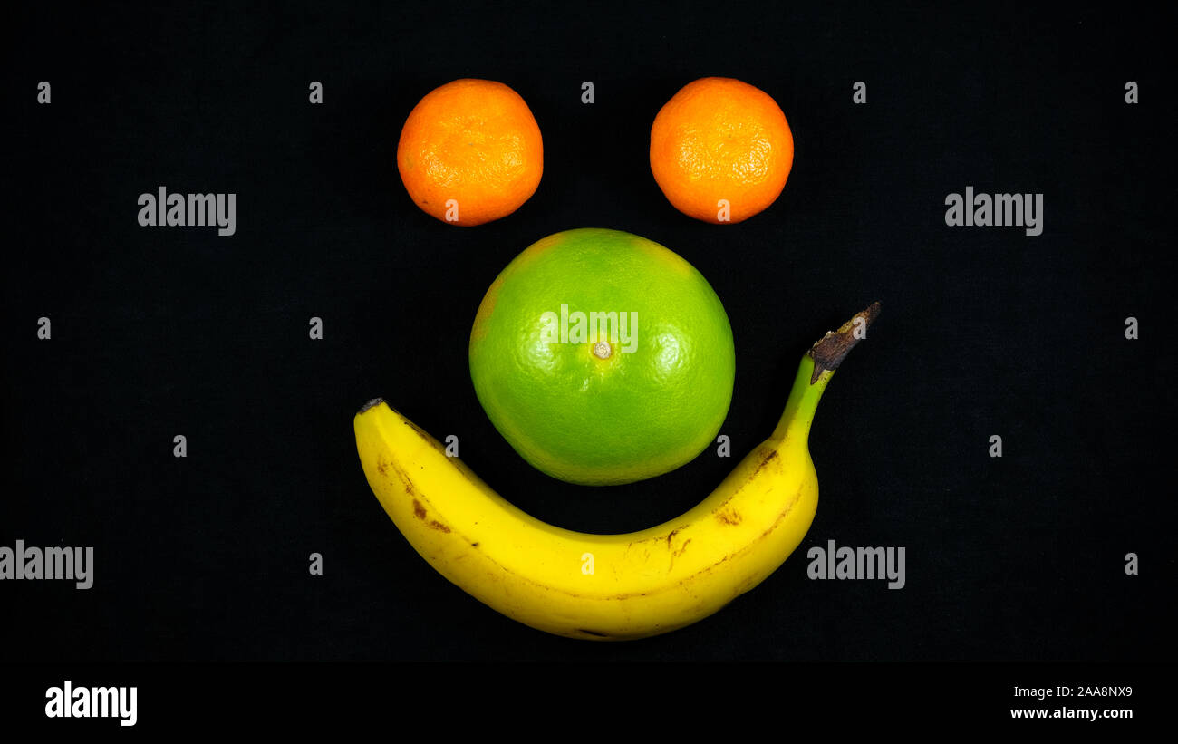 Tangerinen, Sweety und Banane in den schwarzen Hintergrund Stockfoto