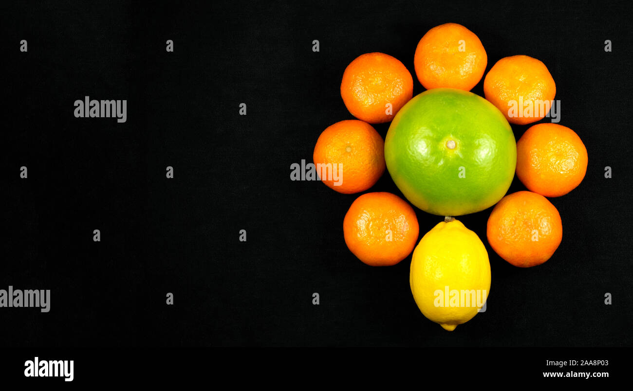 Mandarinen, Sweetie und Zitrone auf schwarzem Hintergrund Stockfoto
