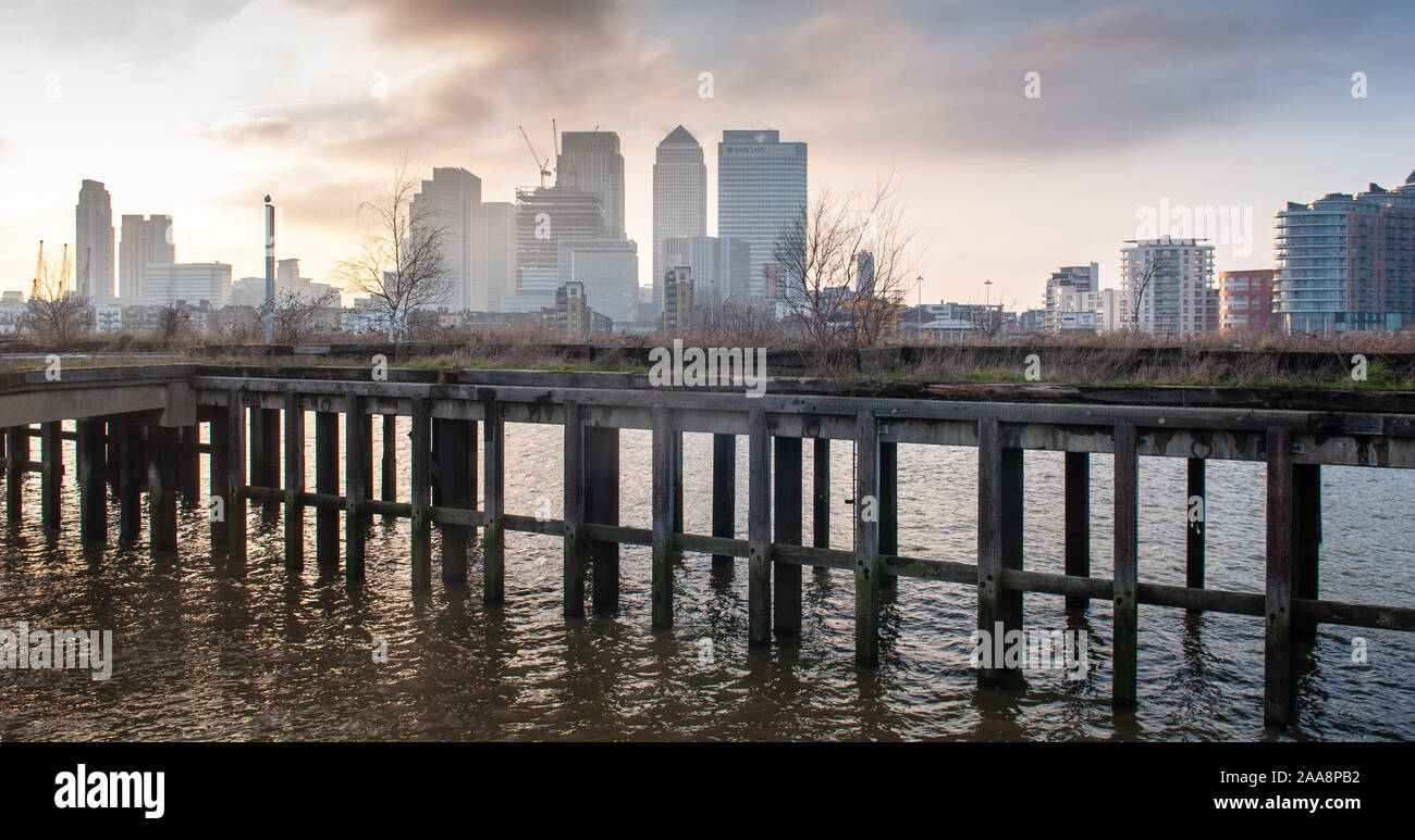 London, England, UK - 17. Februar 2013: Office Wolkenkratzer des Canary Wharf Financial District Aufstieg hinter einem verlassenen und bewachsene industriellen p Stockfoto