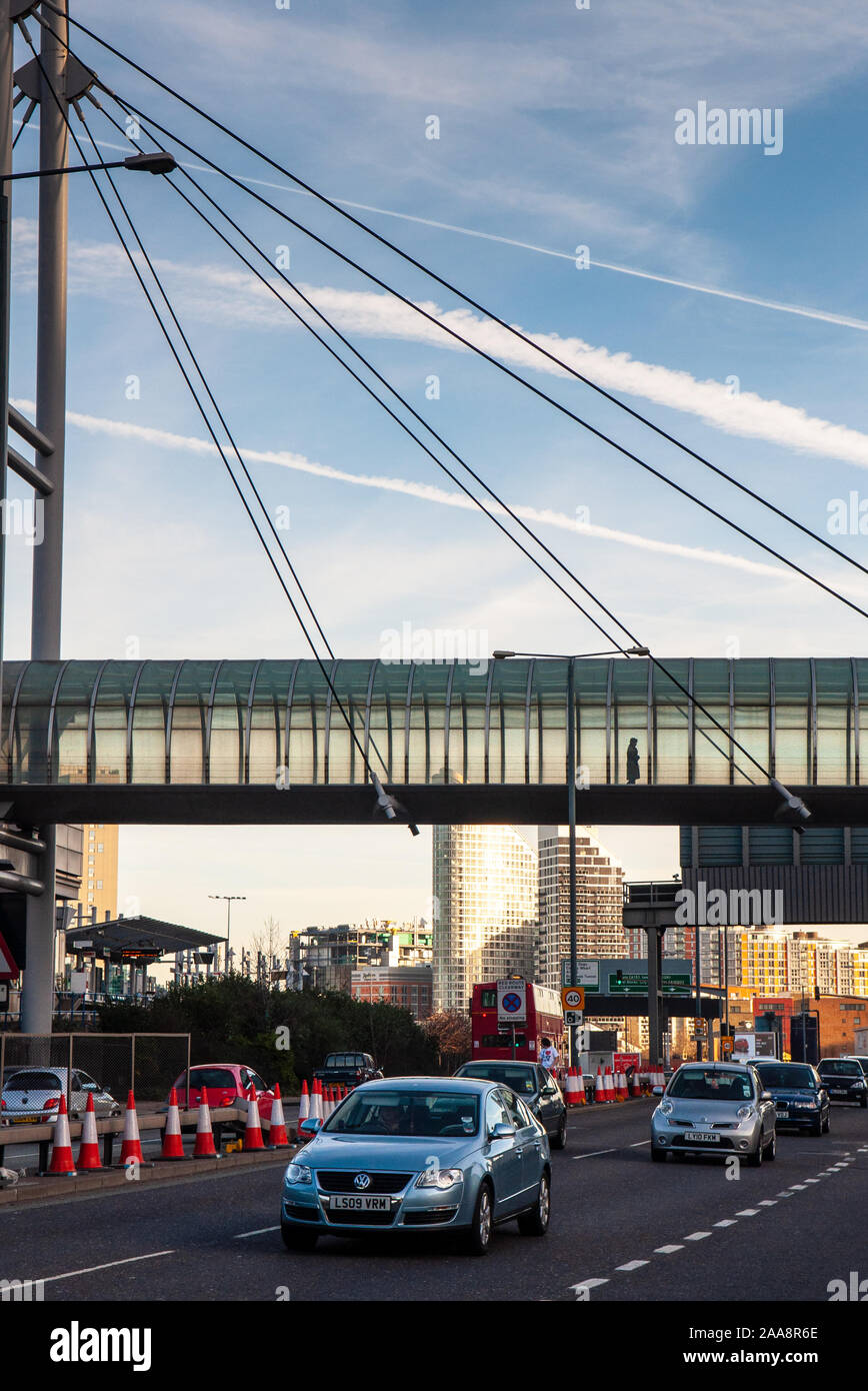 London, England, UK - 10. Dezember 2011: Verkehr fließt entlang West India Dock Road unter der Fußgängerbrücke zur Pappel DLR Station in den Docklands sanieren Stockfoto