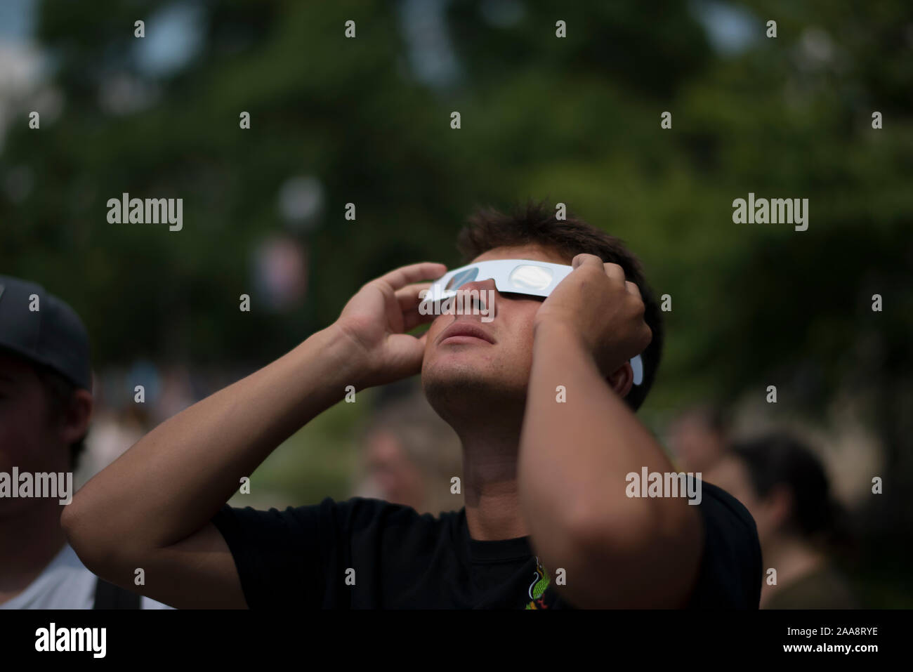Junger Mann auf der Suche bei Sonnenfinsternis Schutzbrille tragen Papier Stockfoto