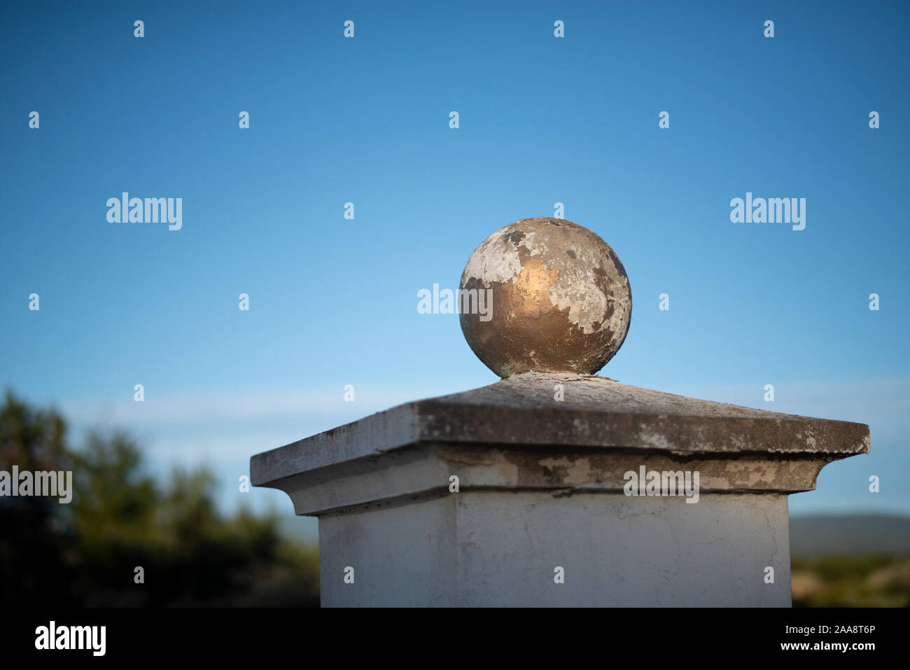 Alte verwitterte goldene Kugel mit abblätternder Farbe auf einem Friedhof Stockfoto