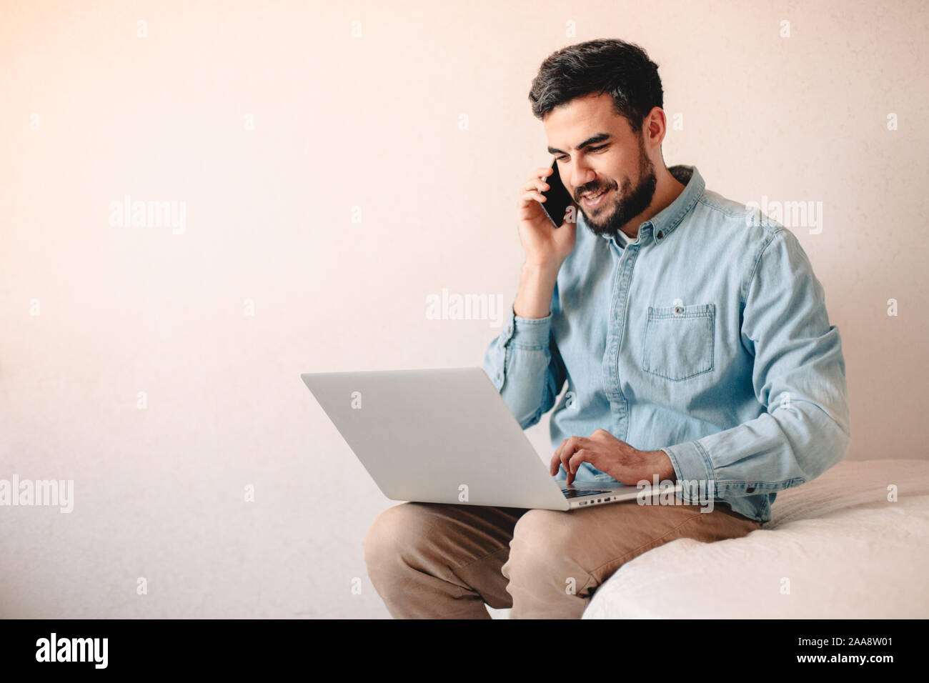 Gerne Unternehmer sprechen über smart phone mit Laptop zu Hause Stockfoto
