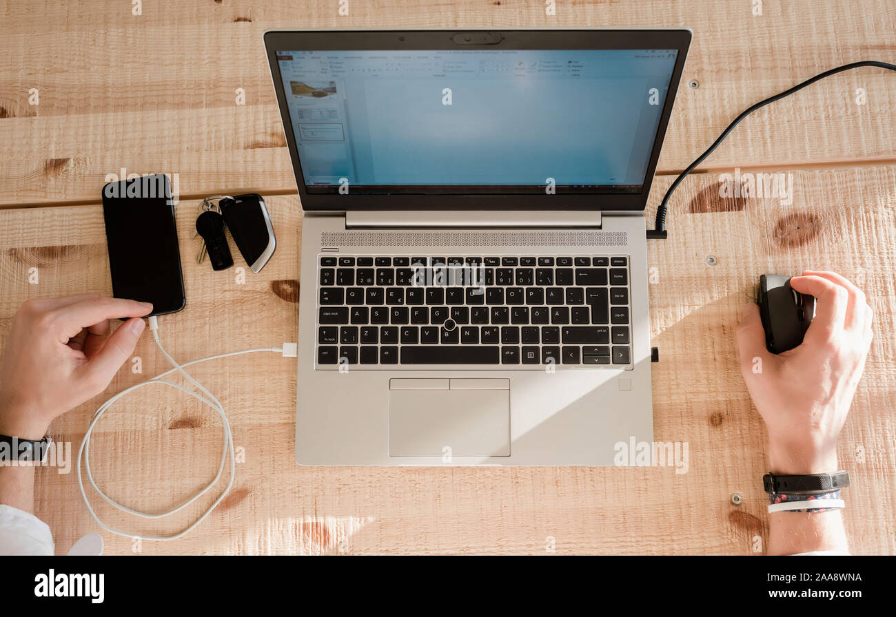 Sky View eines Menschen arbeiten von zu Hause mit seinem Telefon und Laptop Stockfoto