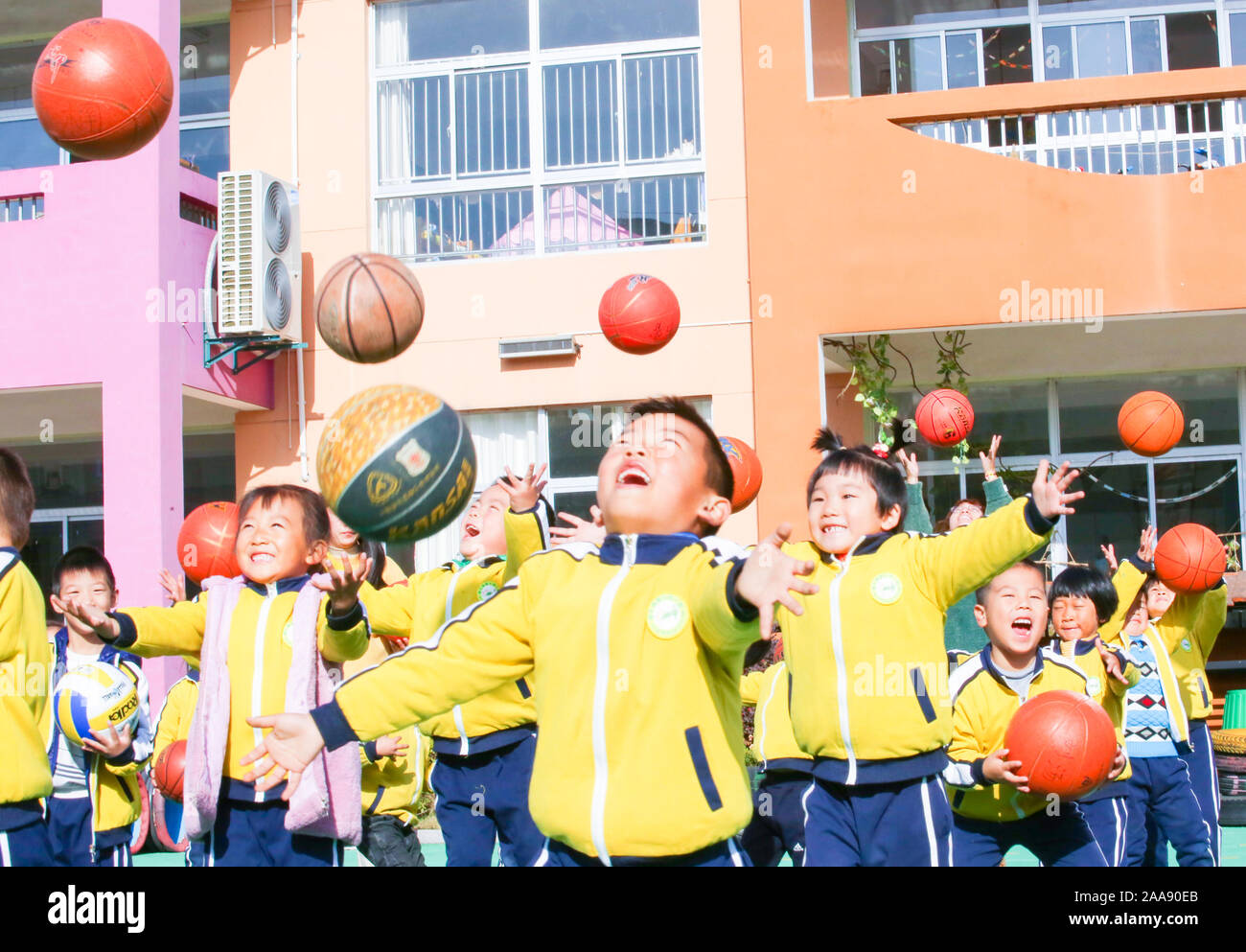 Junge chinesische Kinder haben Spaß mit basketbälle auf dem Spielplatz der Welt Kinder in einem Kindergarten in Motou Stadt Rugao Stadt, Osten Kinn zu markieren Stockfoto