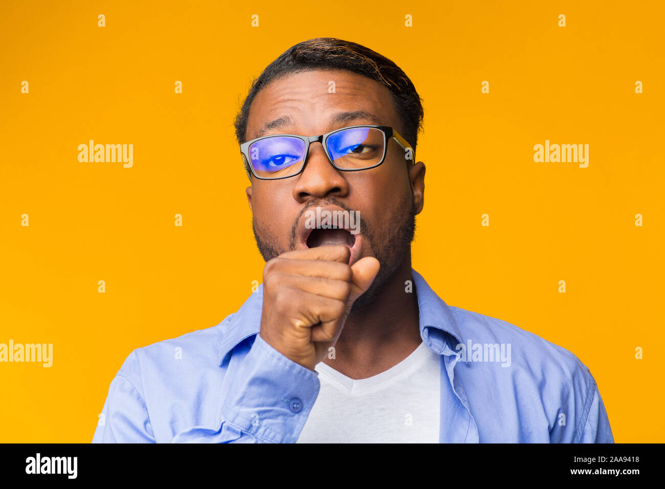 Sleepy Afro Man Gähnen in den Mund mit der Hand, Studio Shot Stockfoto