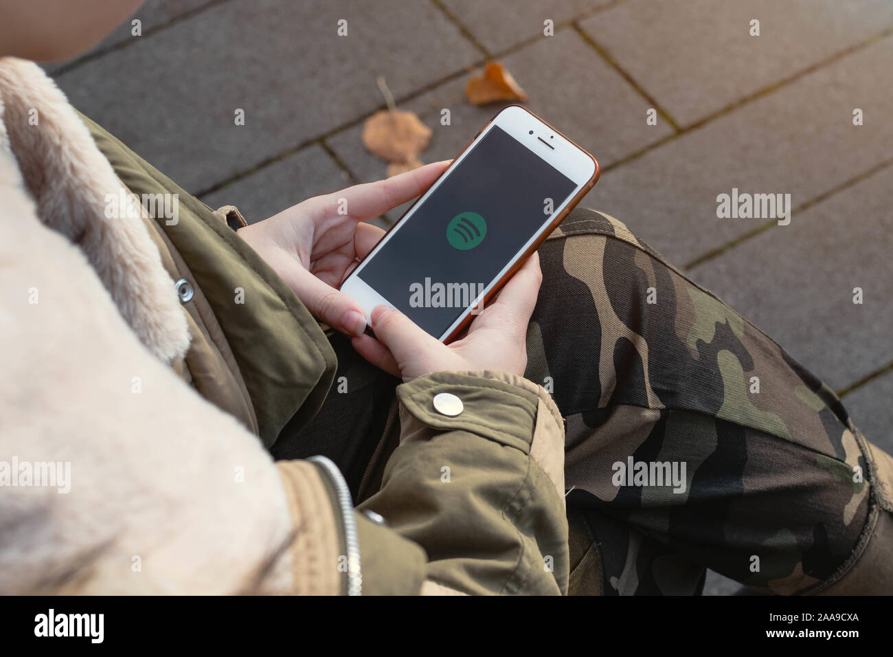 Frau mit einem Handy in der Hand. Spotify Logo auf das Handy. Stockfoto