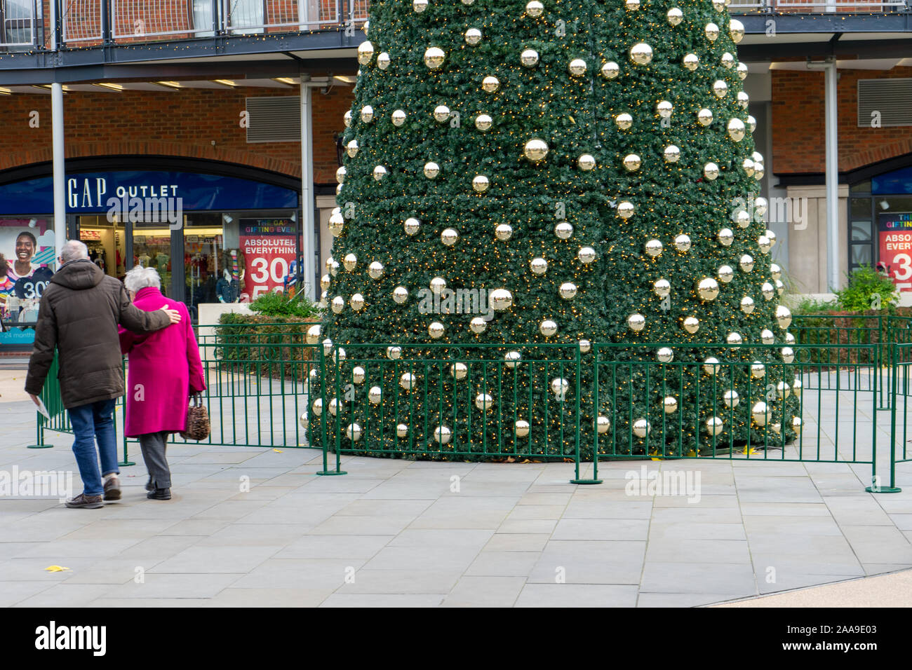 Weihnachtseinkäufer, die an einem großen weihnachtsbaum in der Mitte eines Einkaufszentrums in Portsmouth, Hampshire, Großbritannien, vorbeilaufen Stockfoto
