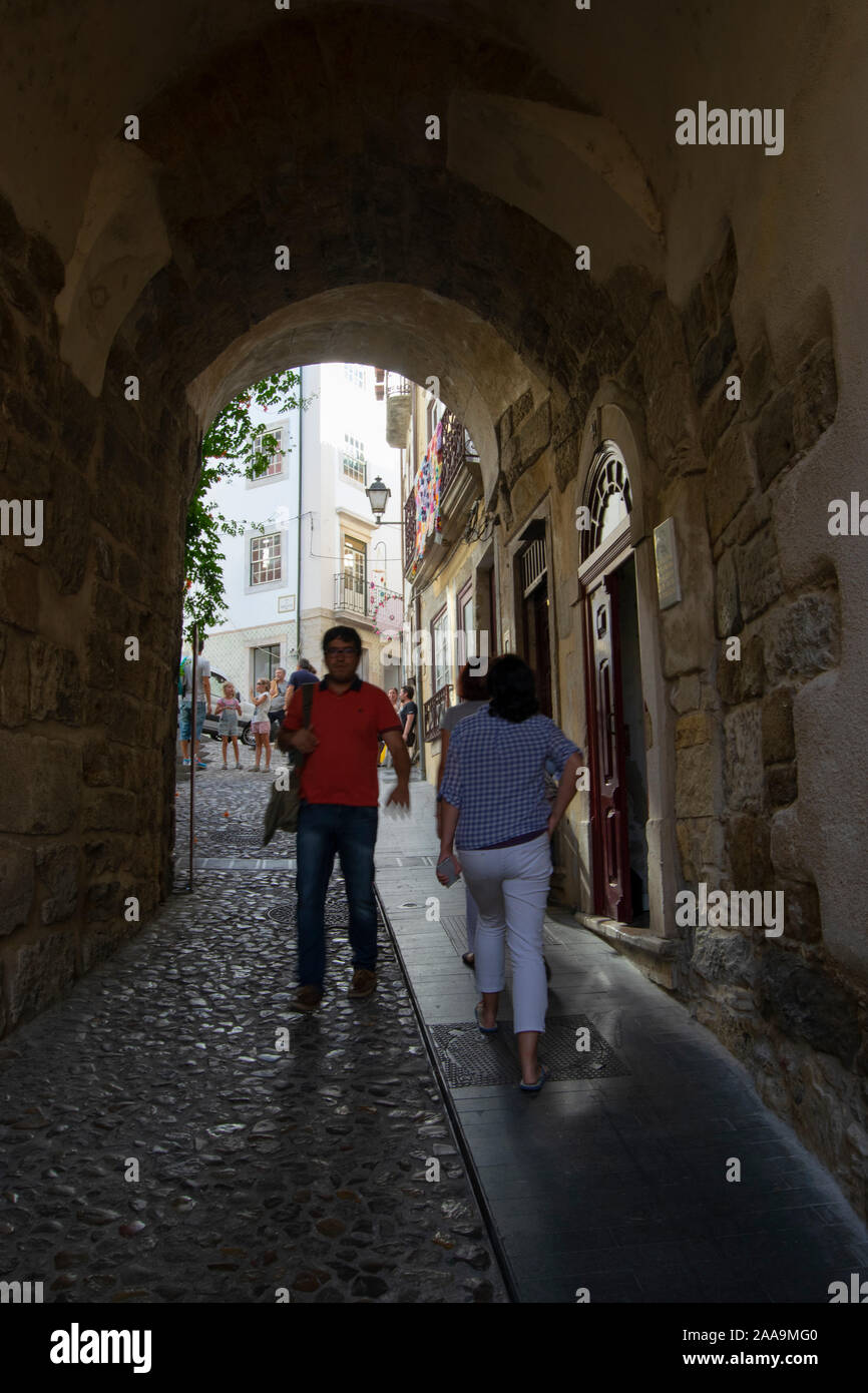 Die Menschen gehen durch die almedina Torbogen in der Altstadt von Coimbra Portugal Stockfoto