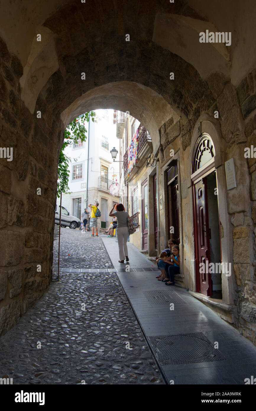 Die Menschen gehen durch die almedina Torbogen in der Altstadt von Coimbra Portugal Stockfoto