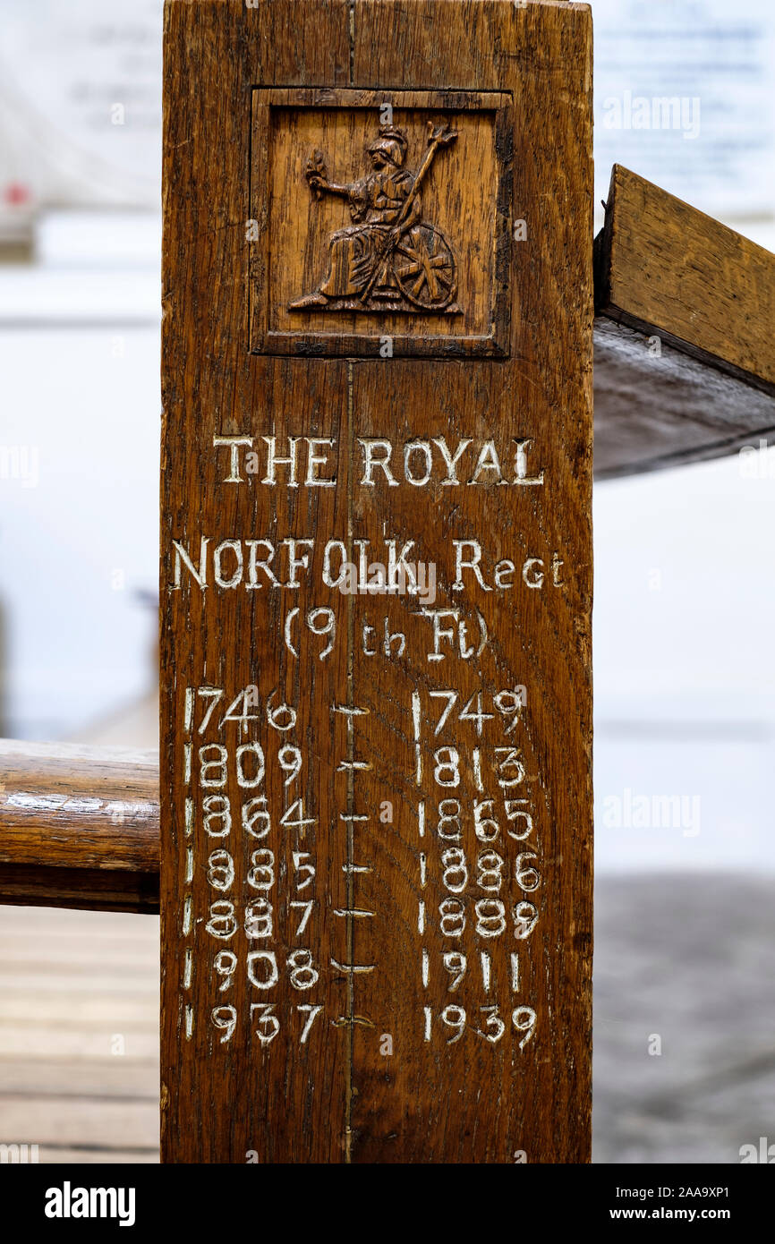 Die Schnitzerei am Ende einer Pew am Heck, die die Postings des Royal Norfolk Regiment in Der King's Chapel, Main Street, Gibraltar darstellt. Stockfoto