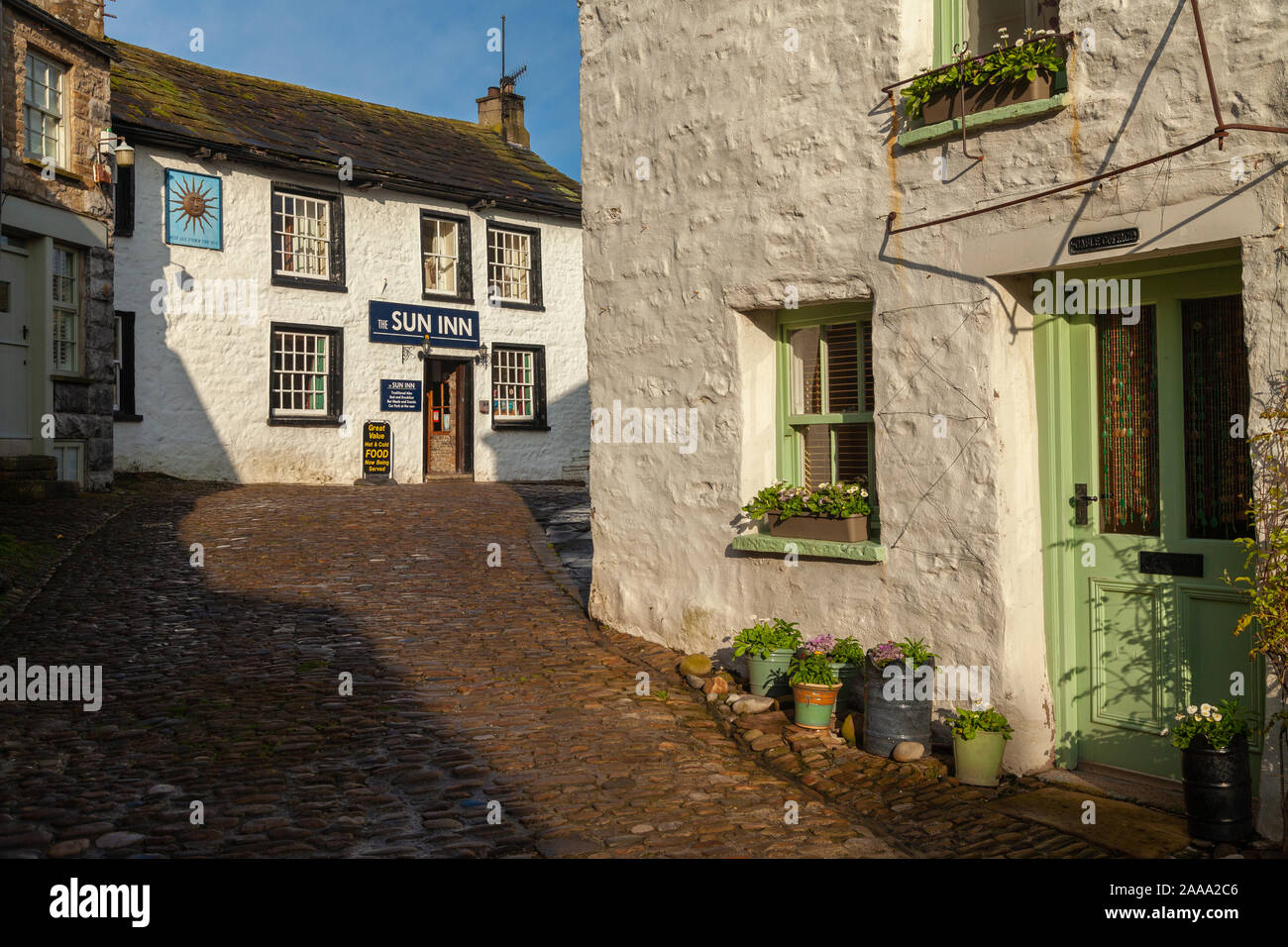 Die malerischen gepflasterten Straßen im Dorf der Einbuchtung, in Dentdale, Cumbria. Stockfoto