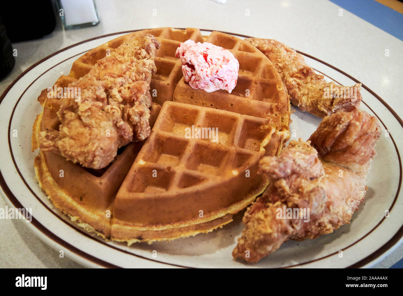 Waffeln und Huhn mit Erdbeeren Butter in einem Restaurant in Savannah Georgia USA Stockfoto
