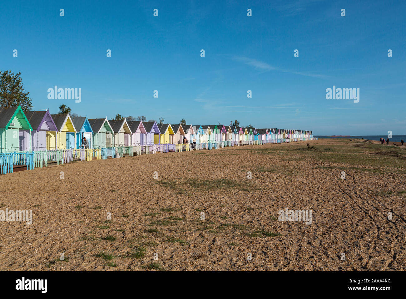 Eine Reihe von pastellfarbenen Holzhütten am West Mersea. Mersea Island, Essex, Vereinigtes Königreich. Stockfoto