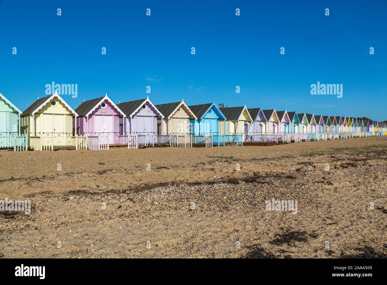 Eine Reihe von pastellfarbenen Holzhütten am West Mersea. Mersea Island, Essex, Vereinigtes Königreich. Stockfoto