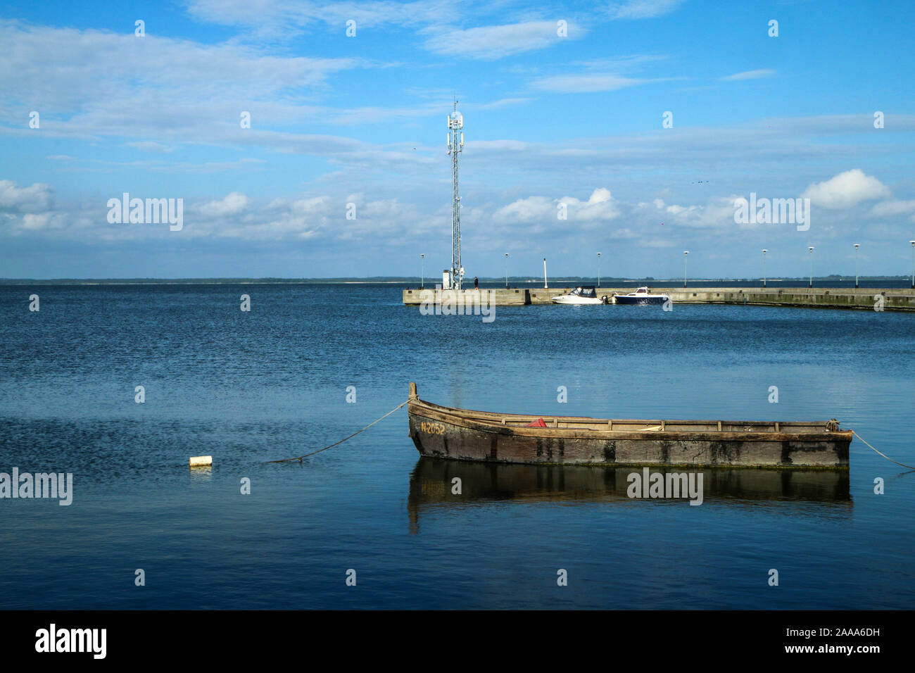 Das ruhige Meer in Litauen in der Stadt Juodkranté. Die alten Fischerboot schwebend durch die Betonpfeiler. Stockfoto