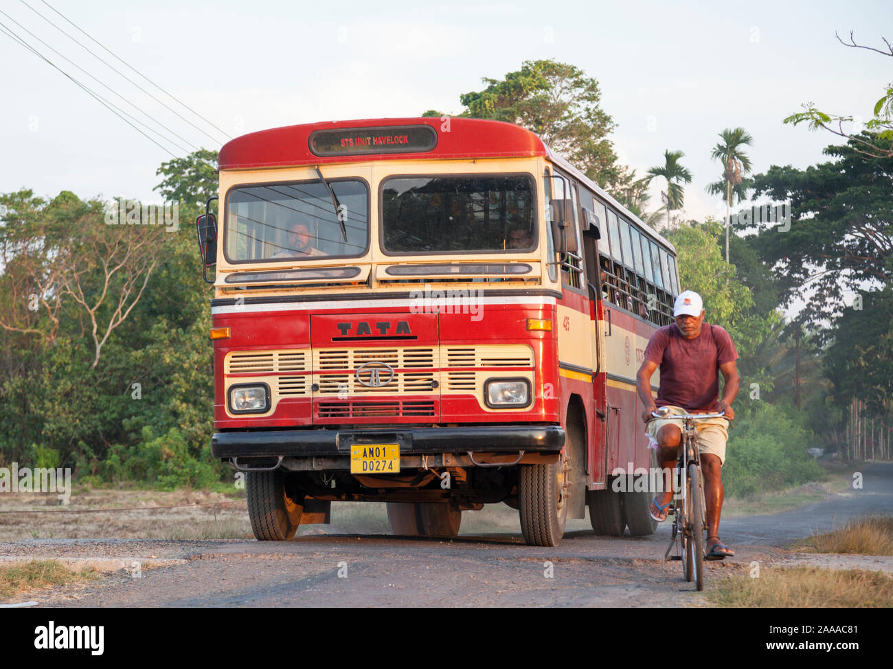 Indische Tata 1512 Bus überholen Radfahrer. Havelock Island, Andaman und Nicobar Inseln Stockfoto