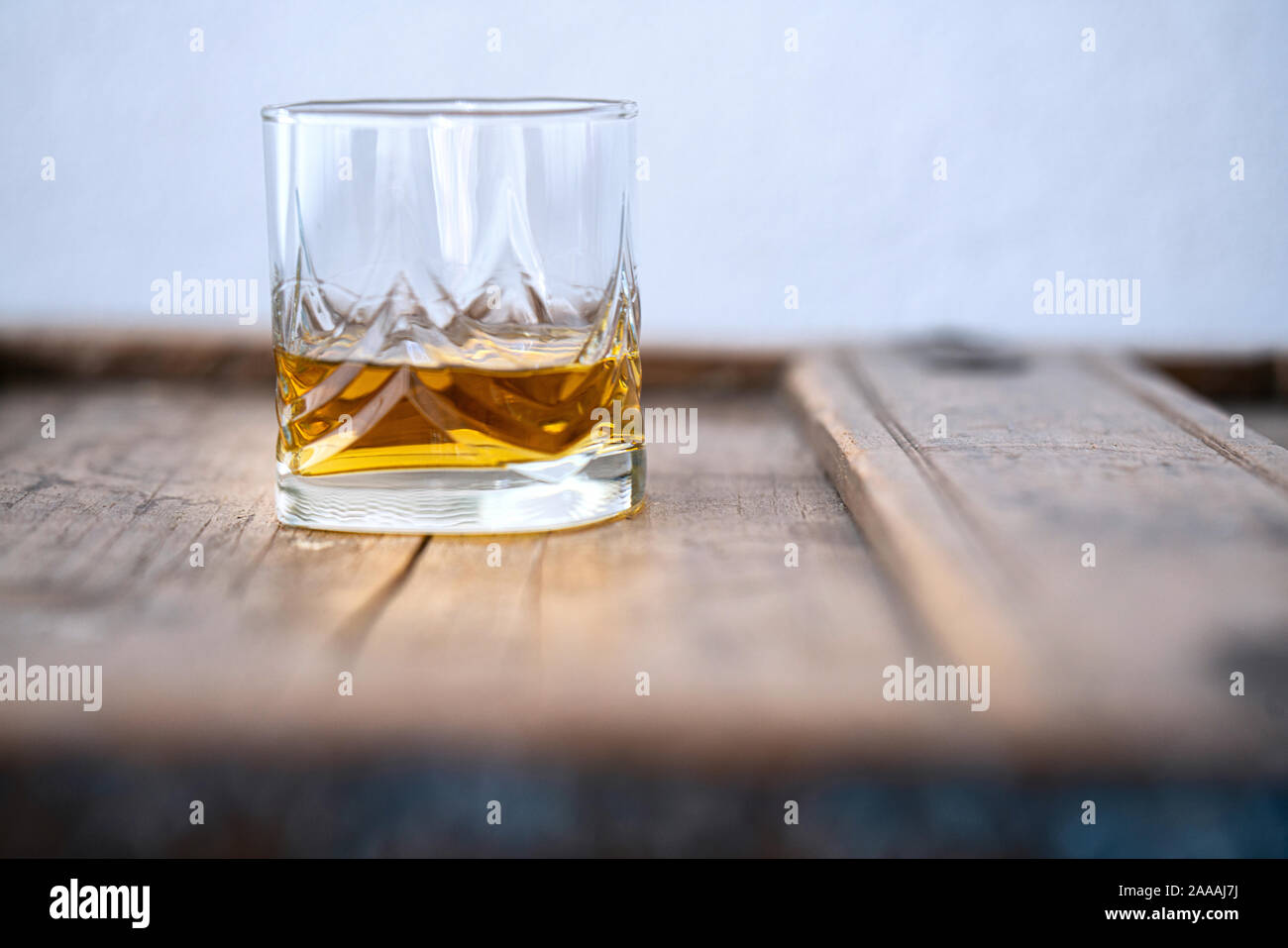 Nahaufnahme eines Whisky Glas auf einen alten Holztisch mit weißem Hintergrund Stockfoto