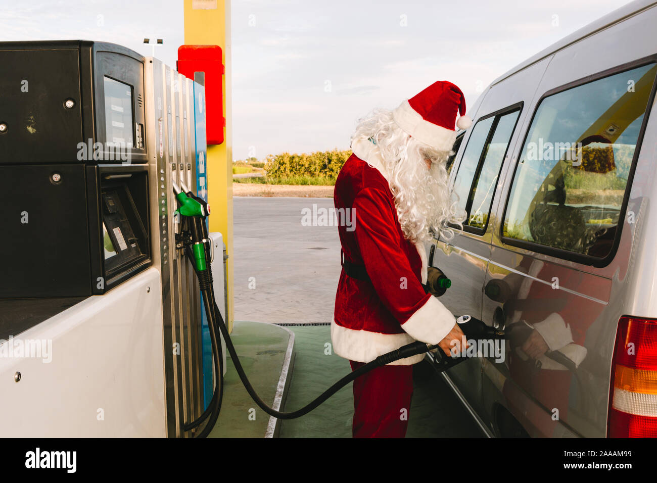 Santa Claus Betankung bis in seinem Auto an einer Tankstelle Stockfoto